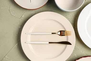 Gri grunge masa üzerinde temiz tabak, kase ve çatal bıçak seti.