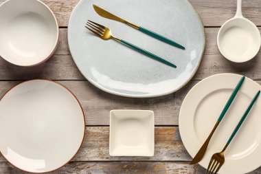 Masa seti, temiz tabaklar, tabaklar ve çatal bıçak takımı ahşap masada.