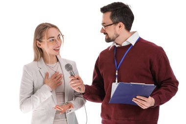 Mikrofonlu bir erkek gazeteci beyaz arka planda bir kadınla röportaj yapıyor.