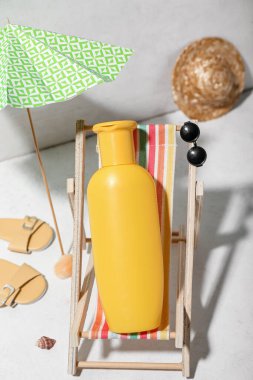 Plaj aksesuarlarıyla yaratıcı kompozisyon ve duvarın yanındaki beyaz masada güneş kremi.