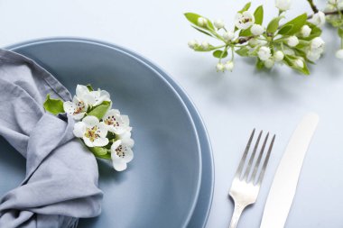 Gri arkaplanda çiçek açan ağaç dalları olan güzel masa ayarları