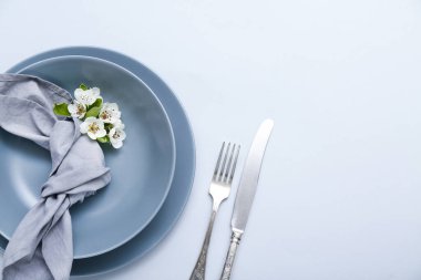 Gri arkaplanda çiçek açan ağaç dalları olan güzel masa ayarları