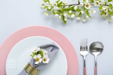 Gri arkaplanda çiçek açan ağaç dalları olan güzel masa ayarları