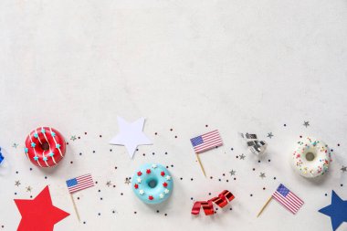 Donutlu kompozisyon, beyaz masada Amerikan bayrakları ve konfeti. Bağımsızlık Günü kutlamaları