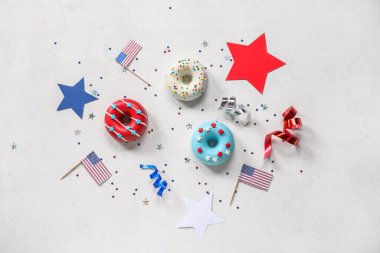 Donutlu kompozisyon, beyaz masada Amerikan bayrakları ve konfeti. Bağımsızlık Günü kutlamaları