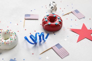 Donutlu kompozisyon, beyaz masada Amerikan bayrakları ve konfeti. Bağımsızlık Günü kutlamaları