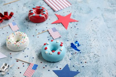 Donutlu kompozisyon, Amerikan bayrakları ve mavi grunge masasında konfeti. Bağımsızlık Günü kutlamaları