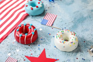 Donutlu kompozisyon, Amerikan bayrakları ve mavi grunge masasında konfeti. Bağımsızlık Günü kutlamaları
