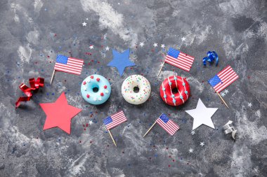 Donutlu kompozisyon, Amerikan bayrakları ve siyah grunge masasında konfeti. Bağımsızlık Günü kutlamaları