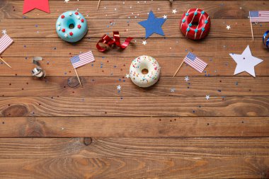 Donutlu kompozisyon, Amerikan bayrakları ve ahşap masada konfeti. Bağımsızlık Günü kutlamaları