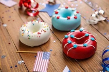 Donutlu kompozisyon, Amerikan bayrakları ve ahşap masada konfeti. Bağımsızlık Günü kutlamaları