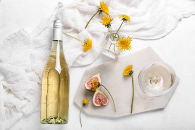 Beyaz arka planda şişe ve bir bardak karahindiba şarabı.