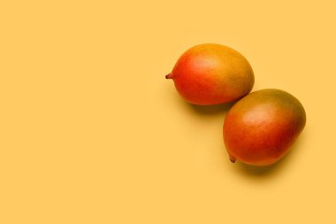 Sarı arka planda taze mangolar.