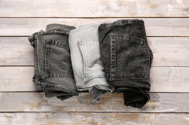 Ahşap arka planda farklı bir kot pantolon.
