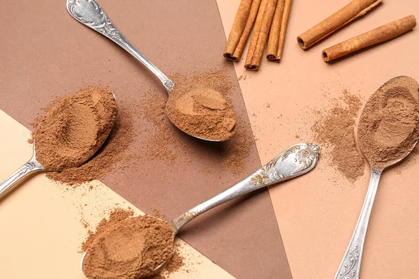 stock image Composition with spoons of cinnamon powder and sticks on color background