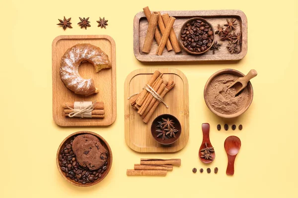 Composition with cinnamon sticks, powder, coffee beans, cake and cookies on yellow background