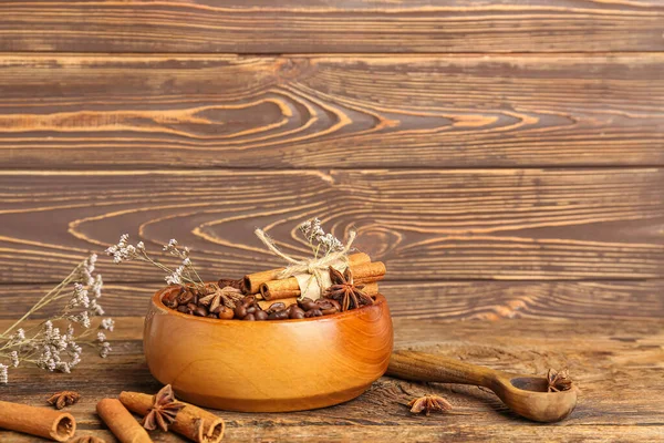 木製の背景にコーヒー豆 シナモンスティックとドライフラワーのボウル — ストック写真