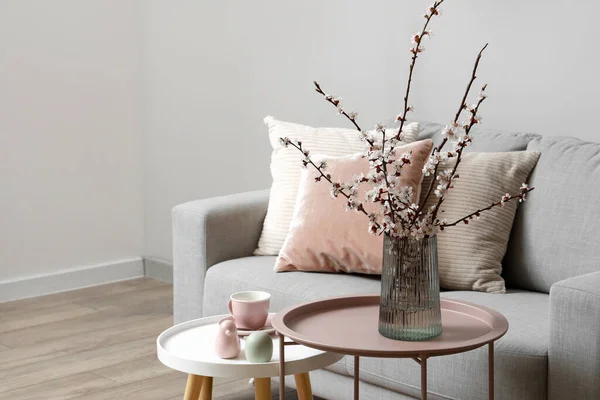 リビングルームのコーヒーテーブルの上に咲く木の枝と花瓶 クローズアップ — ストック写真