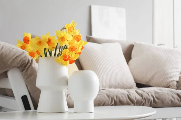 stock image Vase with blooming narcissus flowers on coffee table in living room