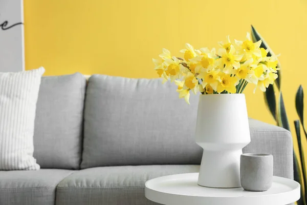花瓶ともに咲くナルシシズムの花とカップ上のコーヒーテーブルでリビングルーム — ストック写真