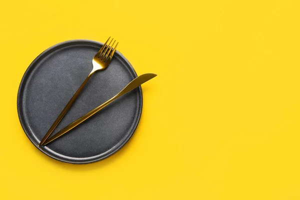 黄底带干净盘子和餐具的餐桌布置 — 图库照片