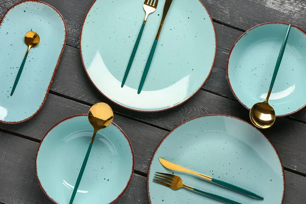Tischdecken Mit Sauberen Tellern Und Besteck Auf Schwarzem Holztisch — Stockfoto