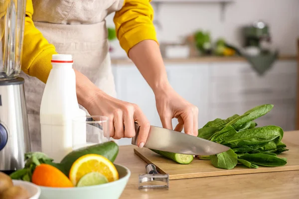 stock image Mature woman cutting cucumber for healthy smoothie in kitchen, closeup