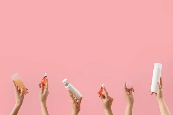 Ruce Držící Kosmetické Přípravky Růžovém Pozadí — Stock fotografie