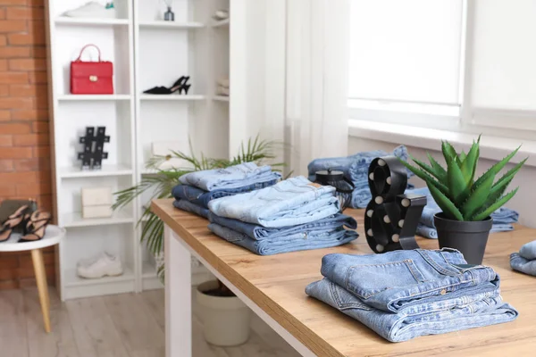 Mesa Com Calças Jeans Elegantes Boutique Moderno Close — Fotografia de Stock