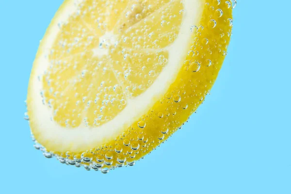 Zitronenscheibe Wasser Mit Blasen Auf Blauem Hintergrund — Stockfoto