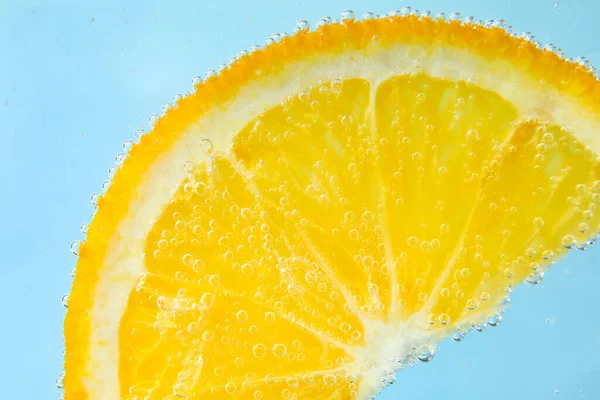 Orange Skiva Vatten Med Bubblor Blå Bakgrund — Stockfoto