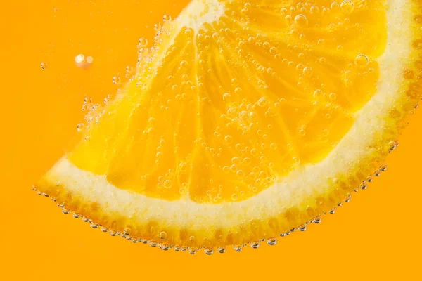 水にオレンジのスライスと泡の色の背景 — ストック写真