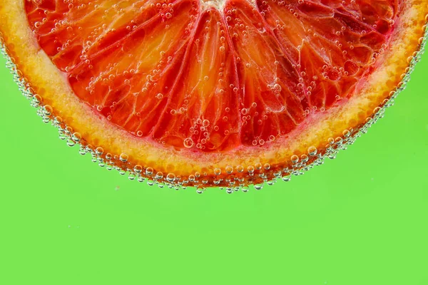 Кровь Оранжевый Ломтик Воде Пузырьками Зеленом Фоне — стоковое фото