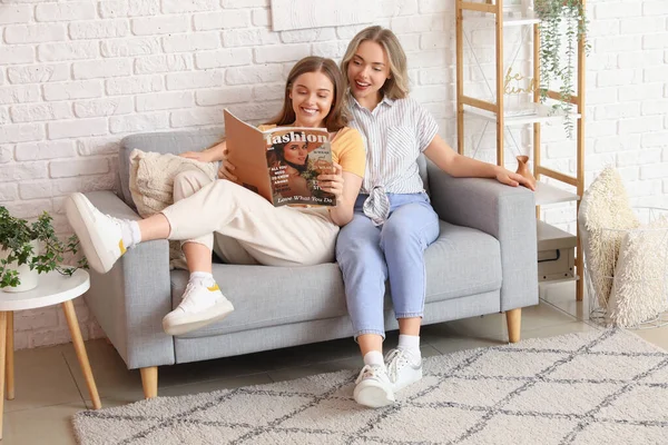 Young Sisters Reading Magazine Sofa Home — Stock Photo, Image