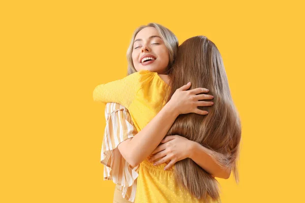 Junge Schwestern Umarmen Sich Auf Gelbem Hintergrund — Stockfoto