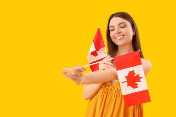 Sarı Arka Planda Kanada Bayrakları Olan Genç Bir Kadın — Stok fotoğraf