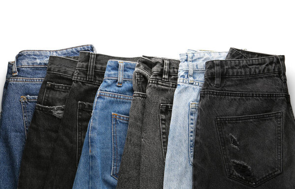 Different stylish denim jeans on white background
