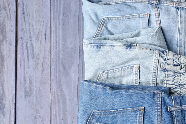 Jeans Denim Piegati Diversi Sfondo Blu Legno — Foto Stock
