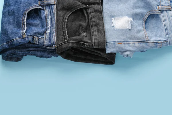 Différents Jeans Pliés Sur Fond Bleu — Photo