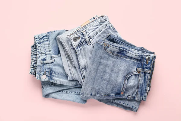 Verschiedene Gefaltete Jeans Auf Rosa Hintergrund — Stockfoto