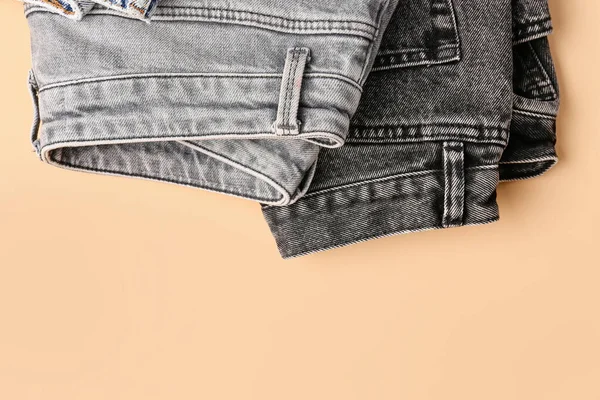 薄いオレンジの背景に異なるスタイリッシュな折り畳みジーンズ — ストック写真