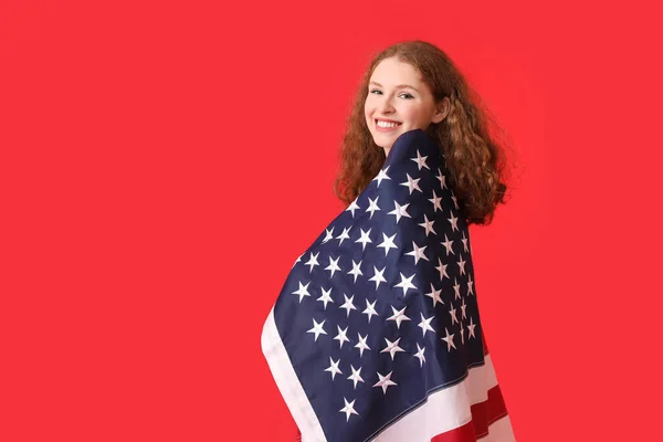 赤を背景にアメリカ国旗を持つ若い女性 — ストック写真