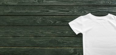 Koyu ahşap arkaplanda boş beyaz tişört ve metin için boşluk