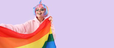 Peruklu ve eflatun arkaplanda LGBT bayrağı olan genç bir kadın.