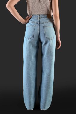 Koyu arka planda şık kotlu genç bir kadın.