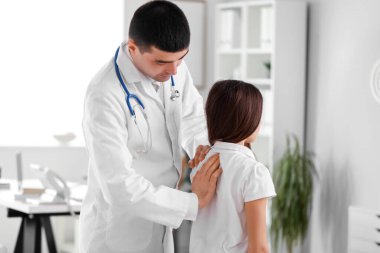 Doktor klinikteki küçük kızın duruşunu kontrol ediyor.