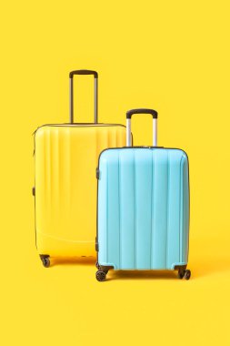 Sarı arka planda büyük bavullar