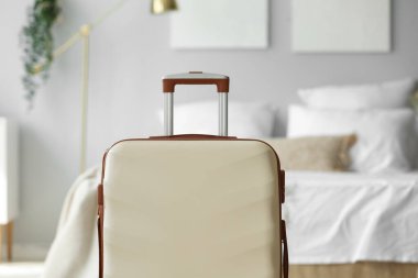 Küçük yatak odasında büyük bir bavul, yakın plan.