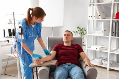 Klinikte olgun donörden kan alan kadın hemşire.