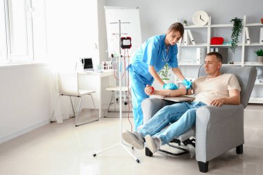 Klinikte olgun donörden kan alan kadın hemşire.